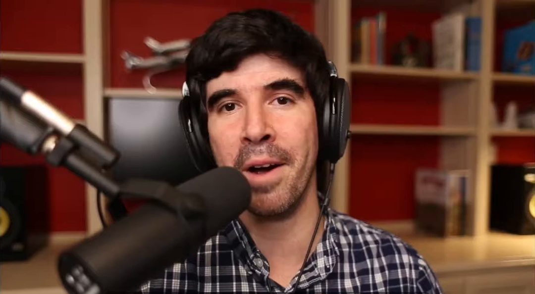 Armando J. Perez-Carreno in a close-up shot, wearing a blue plaid shirt and talking into a microphone on episode 1 of The Web Talk Show